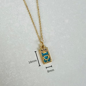 Peut inclure: Collier en or avec un pendentif bleu turquoise repr&eacute;sentant un design de carte de tarot. La carte repr&eacute;sente l'Imp&eacute;ratrice avec une couronne et un c&oelig;ur. Le pendentif mesure 3,5 cm sur 2 cm.