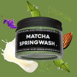 May include: A green jar with a black lid and white text that reads "MATCHA SPRINGWASH." The jar is surrounded by green leaves, white milk, and a brown almond.