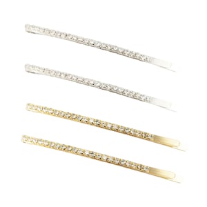 May include: Set of four hair pins with a row of clear rhinestones. Two pins are silver and two are gold.