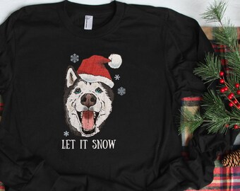 May include: Black long-sleeve t-shirt with a cartoon husky wearing a Santa hat and the text "Let it snow".