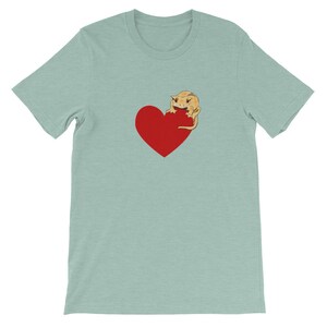 May include: A light blue t-shirt with a red heart and a cartoon crested gecko on it.