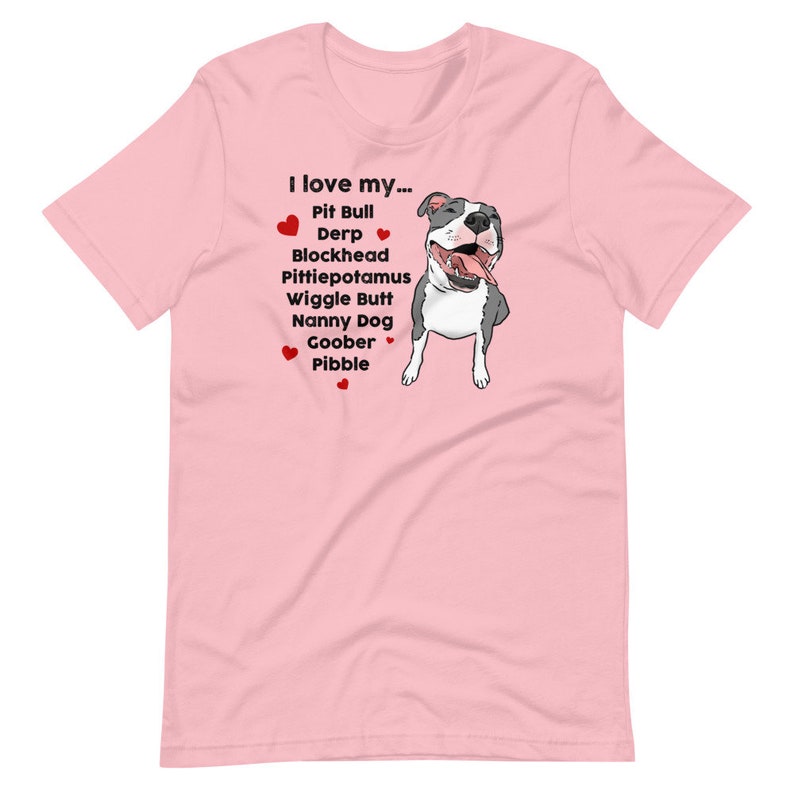 Op de afbeelding: Roze T-shirt met een cartoon afbeelding van een pit bull en de tekst "Ik hou van mijn... Pit Bull Derp Blockhead Pittiepotamus Wiggle Butt Nanny Dog Goober Pibble".