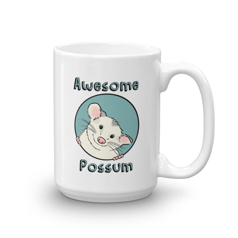 Puede incluir: Taza de cer&aacute;mica blanca con un c&iacute;rculo azul y un opossum de dibujos animados asom&aacute;ndose. El texto "Awesome Possum" est&aacute; impreso en la taza.