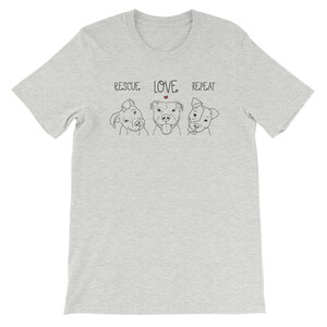 Puede incluir: Una camiseta gris jaspeada con el texto "RESCUE LOVE REPEAT" y tres ilustraciones de perros.