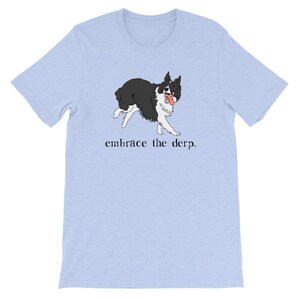 May include: Light blue t-shirt featuring a black and white illustration of a dog with its tongue sticking out. The text "embrace the derp." is printed below the dog.