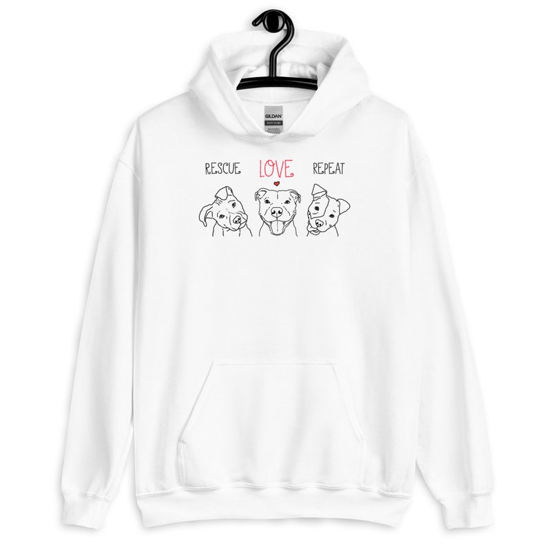 May include: White hoodie with a black line drawing of three dogs and the text "RESCUE LOVE REPEAT" in black with a red heart above the word "LOVE".