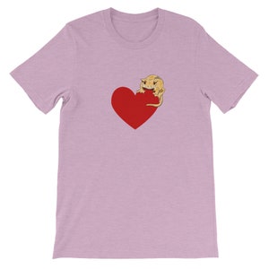May include: A light purple t-shirt with a red heart and a cartoon gecko on it.