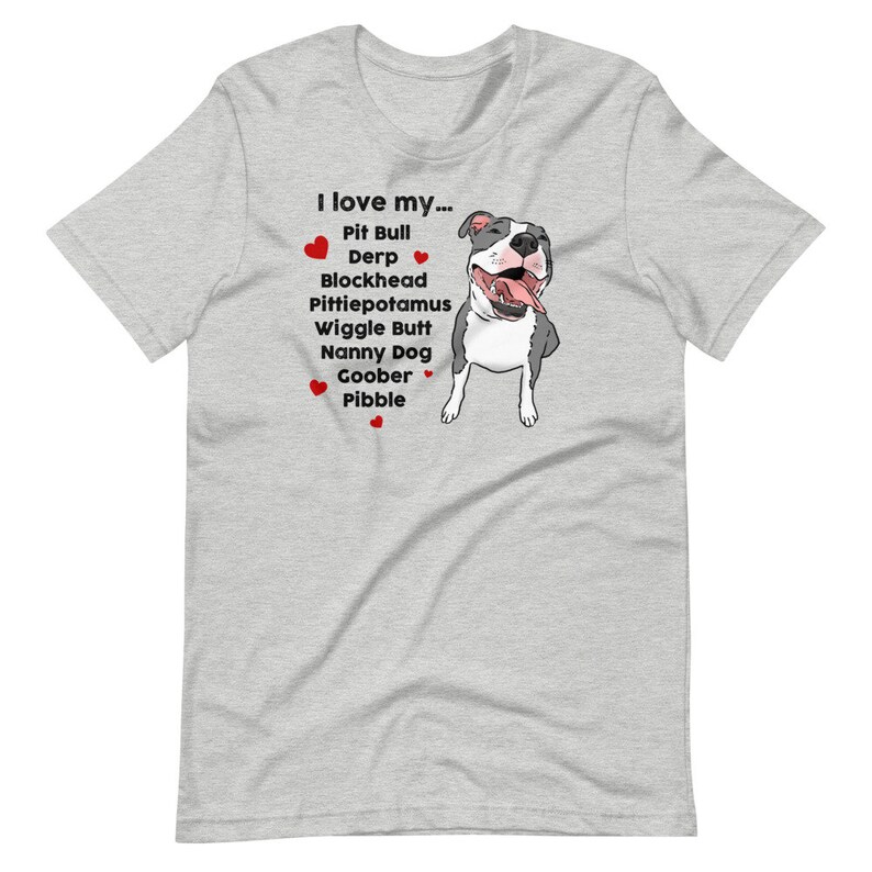 Op de afbeelding: Een grijs T-shirt met een afbeelding van een witte pit bull en de tekst "Ik hou van mijn... Pit Bull Derp Blockhead Pittiepotamus Wiggle Butt Nanny Dog Goober Pibble".