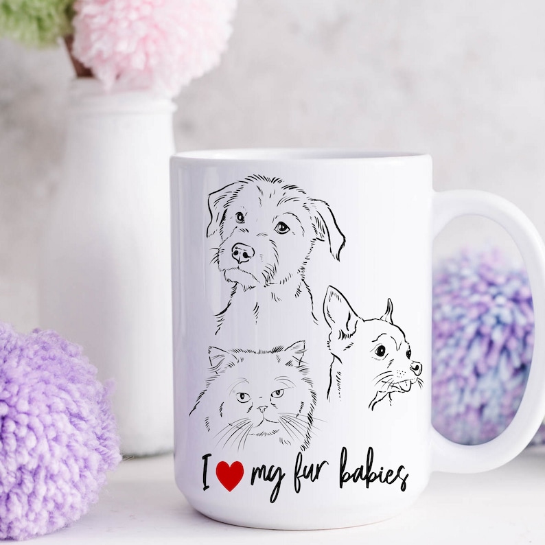 May include: White ceramic mug with a black line drawing of a dog, a cat, and a chihuahua. The mug has the text "I love my fur babies" with a red heart.