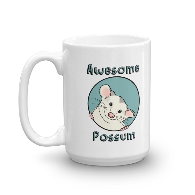 Puede incluir: Taza de cer&aacute;mica blanca con un c&iacute;rculo azul y un opossum de dibujos animados asom&aacute;ndose. El texto "Awesome Possum" est&aacute; impreso en la taza.