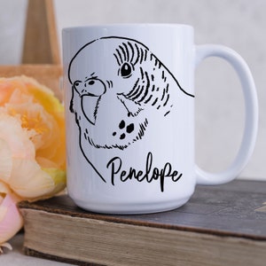 May include: White ceramic mug with a black and white illustration of a parakeet and the name "Penelope" printed on the front.