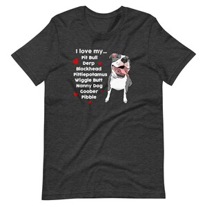 Op de afbeelding: Een donkergrijs T-shirt met een witte afbeelding van een pit bull en de tekst "Ik hou van mijn... Pit Bull Derp Blockhead Pittiepotamus Wiggle Butt Nanny Dog Goober Pibble".