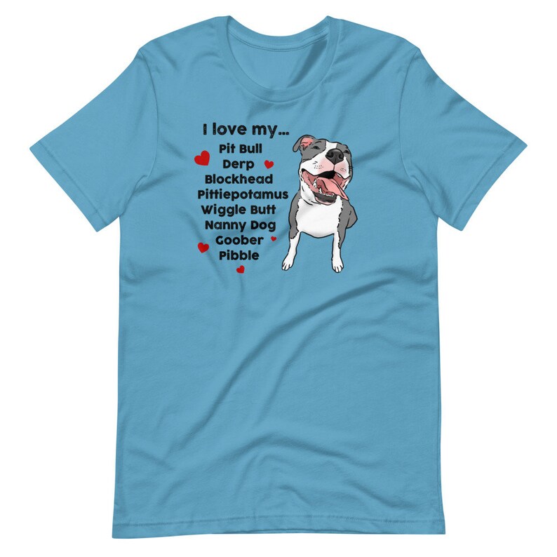 Op de afbeelding: Een lichtblauw t-shirt met een cartoon afbeelding van een pit bull hond en de tekst "Ik hou van mijn... Pit Bull Derp Blockhead Pittiepotamus Wiggle Butt Nanny Dog Goober Pibble".