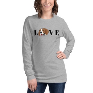 Peut inclure: Un t-shirt gris &agrave; manches longues avec le mot "LOVE" en lettres noires. La t&ecirc;te d'un beagle est dans le "O" du mot.