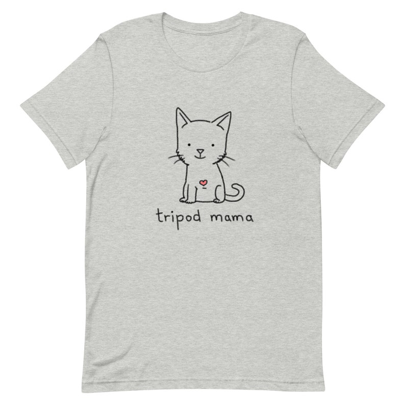 May include: A gray t-shirt with a black and white illustration of a cat with a red heart on its chest. The text "tripod mama" is printed below the cat.