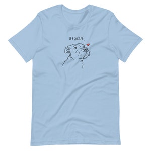 May include: Light blue t-shirt with a black line drawing of a dog looking up at a small red heart. The text "RESCUE." is printed above the dog.