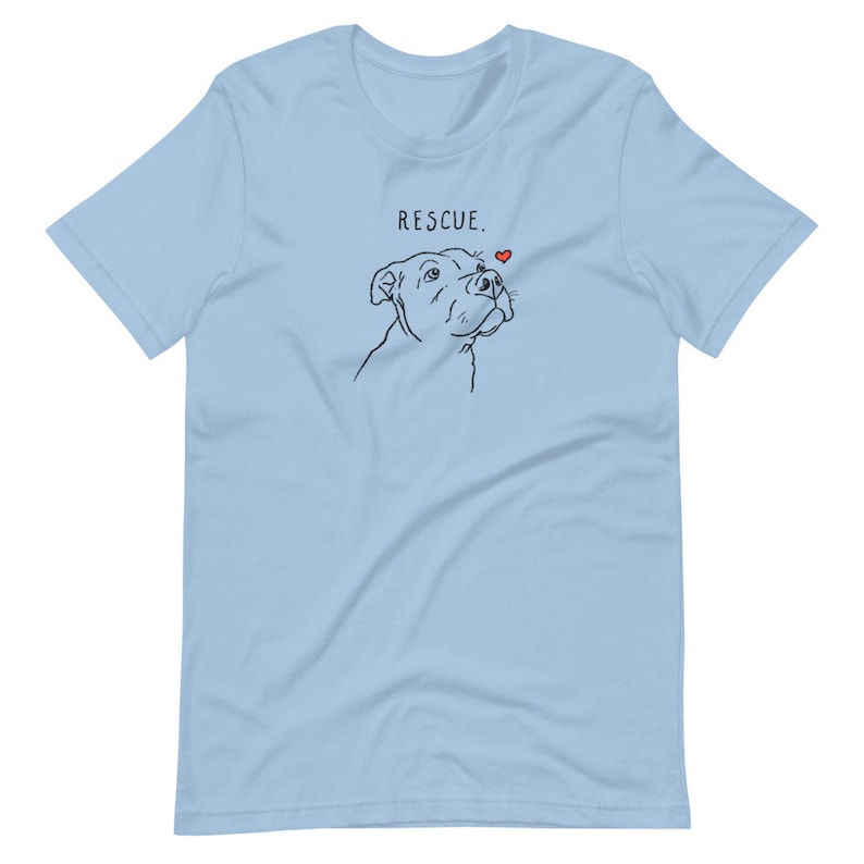 May include: Light blue t-shirt with a black line drawing of a dog looking up at a small red heart. The text "RESCUE." is printed above the dog.
