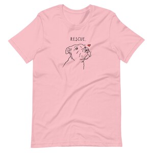 May include: Pink short-sleeved t-shirt with a black line drawing of a dog's head and the text "RESCUE." with a small red heart above the dog's head.