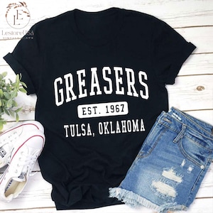 May include: Black t-shirt with white text that reads "Greasers Est. 1967 Tulsa, Oklahoma".