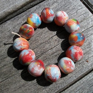 A strand of 12 multi color ceramic round beads