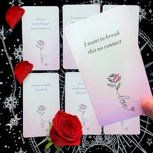 Op de afbeelding: Een set witte orakelkaarten met romantische boodschappen en een rozenillustratie. De kaarten tonen zinnen als "Ik wil dit contact verbreken" en "Jij bent alles wat ik wil en nodig heb". Een rode roos en bloemblaadjes zijn ook zichtbaar.