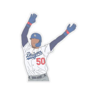 May include: A sticker featuring a baseball player in a white and blue Dodgers uniform, number 50, with arms raised in celebration. The player wears a blue helmet, wristbands, and gloves. The Dodgers logo is visible on the helmet.