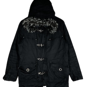 May include: Black hooded jacket with a faux fur collar and multiple silver buckles. The jacket has two large pockets with silver grommets.