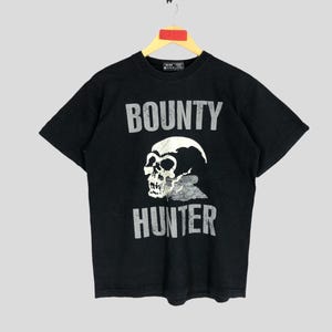 May include: Black t-shirt with a white skull graphic and the text "BOUNTY HUNTER" printed on the front.