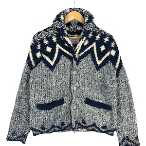 May include: A blue and white patterned cardigan with a shawl collar and button closure. The cardigan has two pockets and a textured knit.