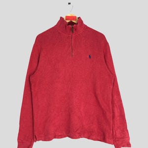 May include: A red long-sleeved quarter-zip sweater with a small embroidered polo player logo on the chest.