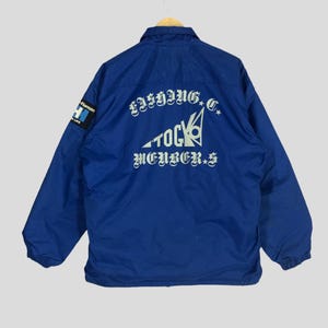 May include: A blue jacket with a white logo on the back that says "Fishing Club Tokyo Members".
