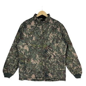 May include: A green, brown, and beige camouflage print jacket with a zipper closure. The jacket has a stand-up collar and long sleeves.