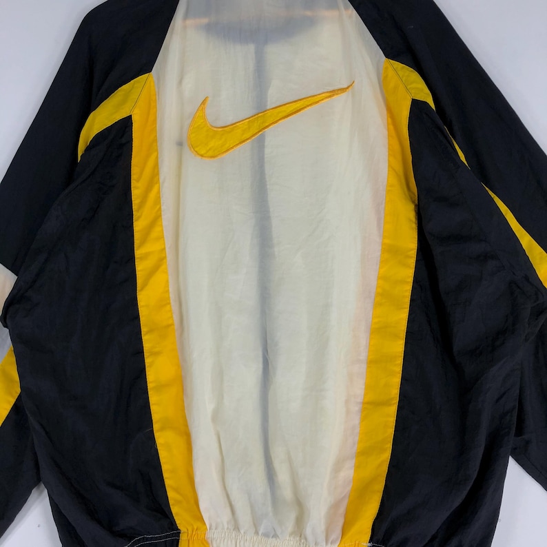 May include: Black and yellow windbreaker jacket with a white mesh lining and a large Nike logo on the back.