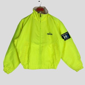May include: Bright yellow jacket with a zip-up front, two pockets, and a stand-up collar. Features the text "CROSS ROAD" and a "Helly Hansen SEA LIFE" patch on the sleeve. The jacket has a light beige lining.