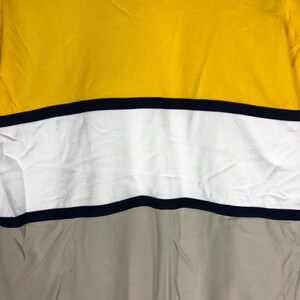 May include: A yellow, white and beige striped t-shirt with black stripes.