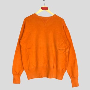 Peut inclure: Sweat-shirt à manches longues orange avec un col rond.