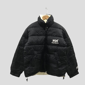 May include: A black puffer jacket with a high collar and a full-length front zipper. The chest features the white text HH and Helly Hansen. The jacket has long sleeves with elastic cuffs, two side pockets, and a drawstring hem at the bottom.