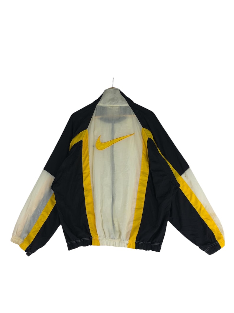 May include: A black and yellow windbreaker jacket with a white mesh lining and a Nike logo on the back.
