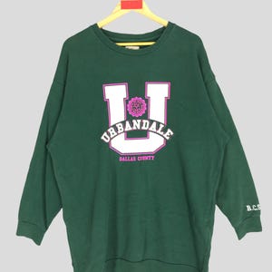 May include: Green sweatshirt with a white "U" and the text "URBANDALE DALLAS COUNTY" in pink lettering.
