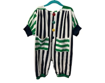 May include: A striped baby onesie with green and white stripes and a black background. The onesie has a round neckline and short sleeves. It has three colorful buttons down the front.