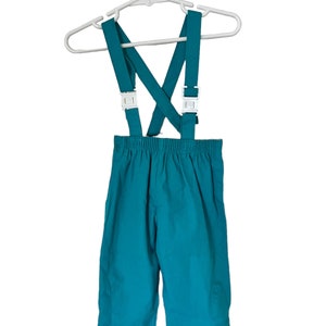 May include: Teal blue children's overalls with adjustable straps and white plastic buckles. The overalls are hanging on a white plastic hanger.