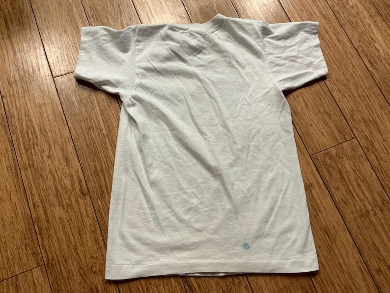 May include: A plain white t-shirt with a crew neck and short sleeves. The shirt is made of a soft, lightweight fabric.