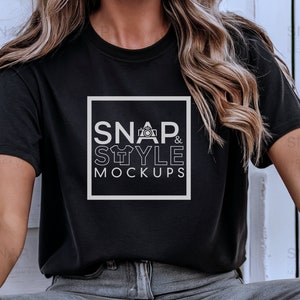 Puede incluir: Una camiseta negra con un gr&aacute;fico blanco que dice "SNAP & STYLE MOCKUPS" con un icono de c&aacute;mara y una camiseta.