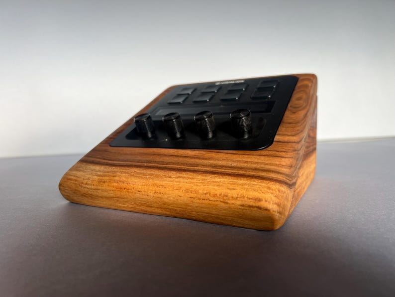 以下が含まれることがあります： 黒いコントロールパネルとノブを備えた木製の電子機器。デバイスは、丸みを帯びたエッジと天然の木目仕上げの長方形の形状をしています。コントロールパネルには、いくつかのボタンとノブがあります。