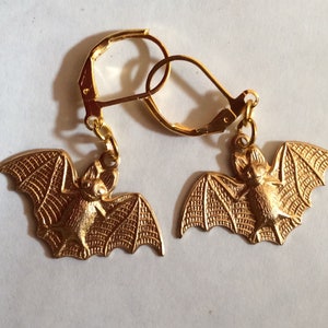 May include: A pair of gold-tone bat earrings with a detailed design. The earrings have a leverback fastening.