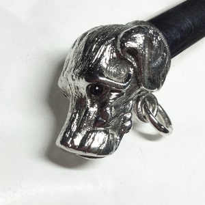 May include: Silver dog head cane topper with a black leather handle.