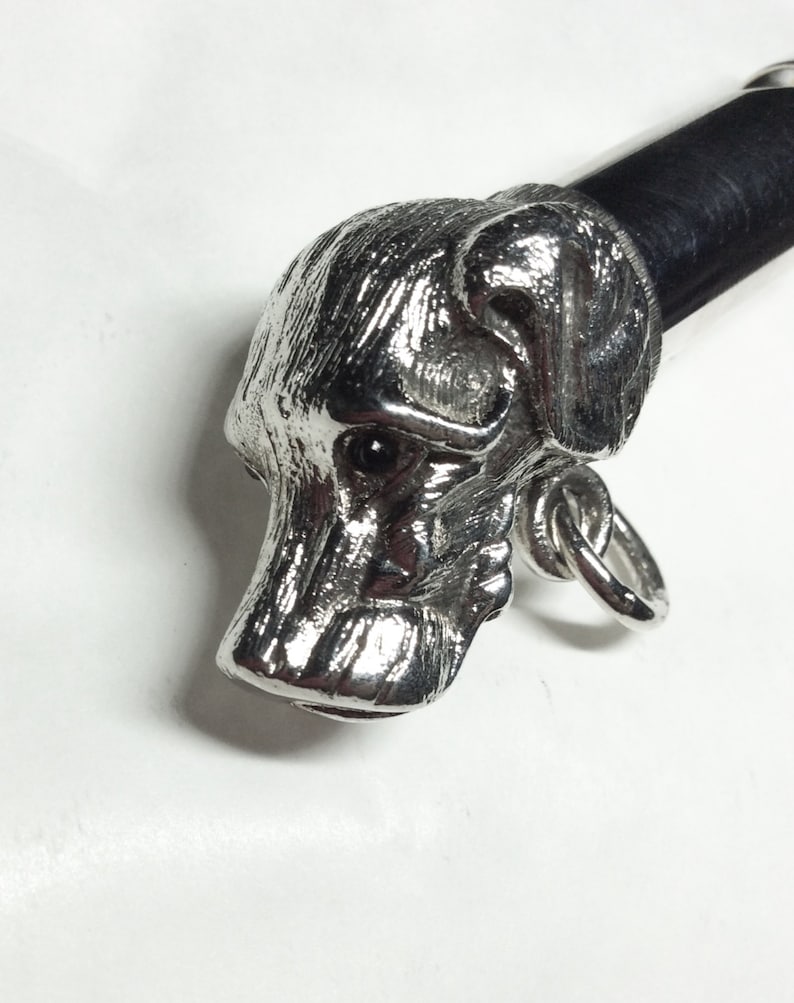 May include: Silver dog head cane topper with a black leather handle.