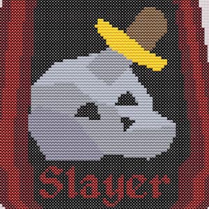 Può includere: Un teschio bianco con un cappello giallo e un bordo marrone, con la parola "Slayer" in lettere rosse sotto. Il teschio è incorniciato da un bordo rosso.