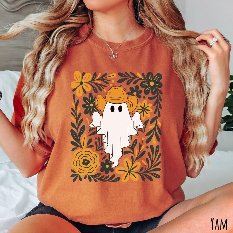 Yam Comfort Colors t-shirt featuring a cute ghost wearing a cowboy hat, surrounded by yellow and green floral designs—perfect for fall, Halloween, and western style lovers.