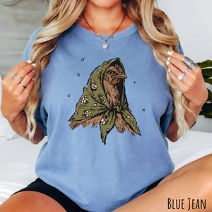 Blue jean Comfort Colors unisex t-shirt featuring an illustrated hen wearing a green floral headscarf.